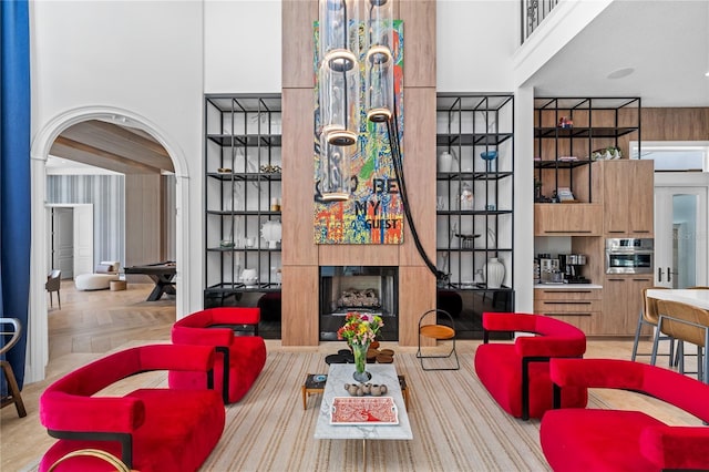 living room with a towering ceiling and light parquet floors