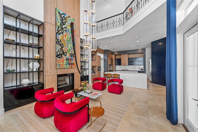 tiled living room featuring a fireplace and a towering ceiling