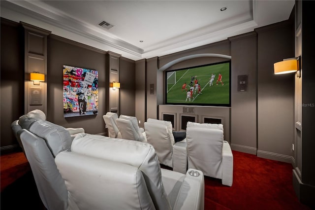 carpeted cinema room featuring a tray ceiling and ornamental molding