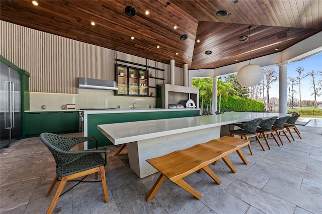 bar with wood ceiling, high vaulted ceiling, green cabinetry, hanging light fixtures, and range hood