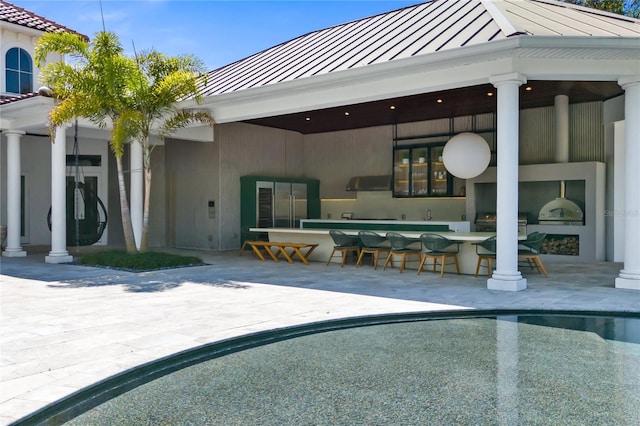 view of swimming pool featuring a bar, area for grilling, and a patio area