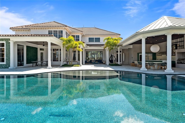 view of pool with a patio, an outdoor bar, and ceiling fan