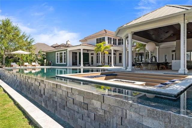 back of property featuring ceiling fan and a patio