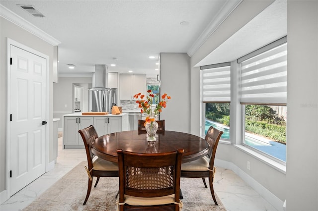 dining room with a textured ceiling and ornamental molding