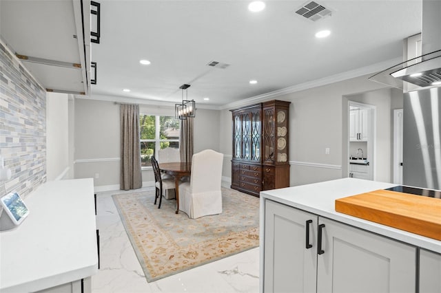 kitchen featuring white cabinetry, hanging light fixtures, and ornamental molding