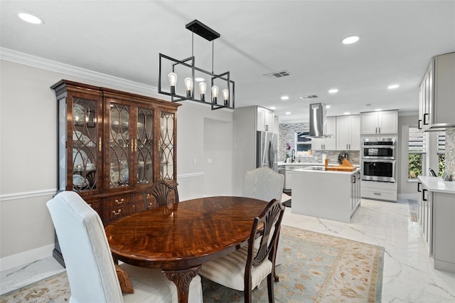 dining area with crown molding, sink, and a notable chandelier