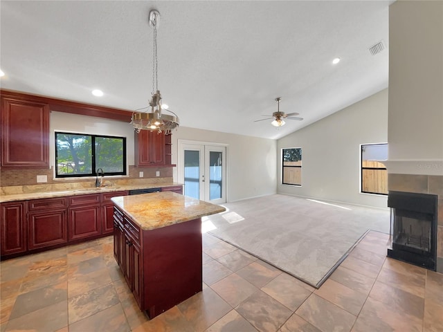 kitchen featuring a center island, sink, pendant lighting, vaulted ceiling, and carpet