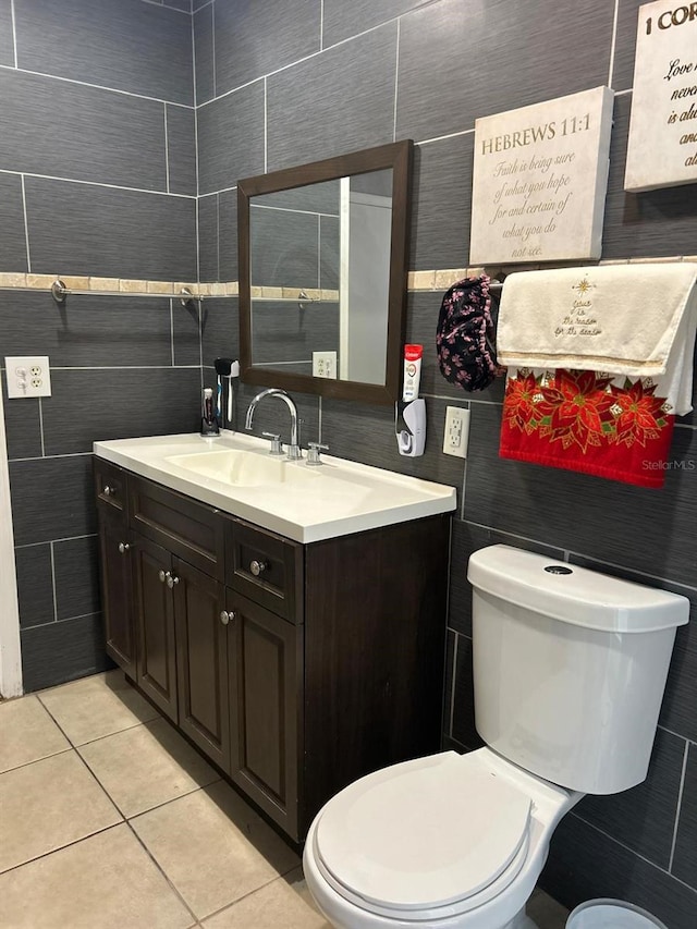 bathroom featuring tile patterned floors, vanity, tile walls, and toilet