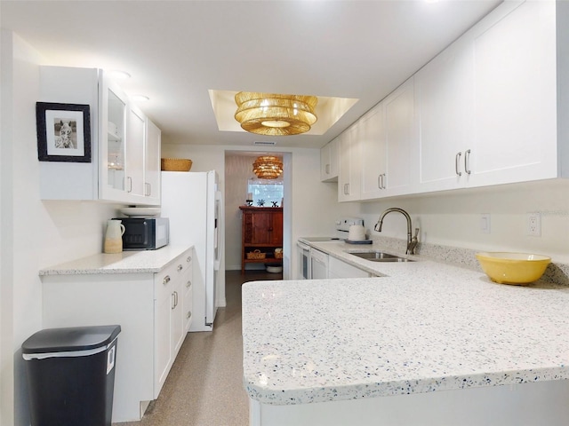 kitchen featuring kitchen peninsula, white appliances, white cabinetry, and sink