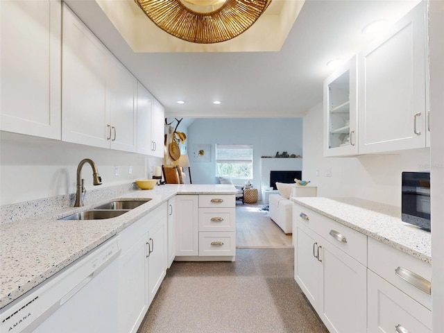 kitchen featuring white cabinetry, dishwasher, sink, and light stone countertops