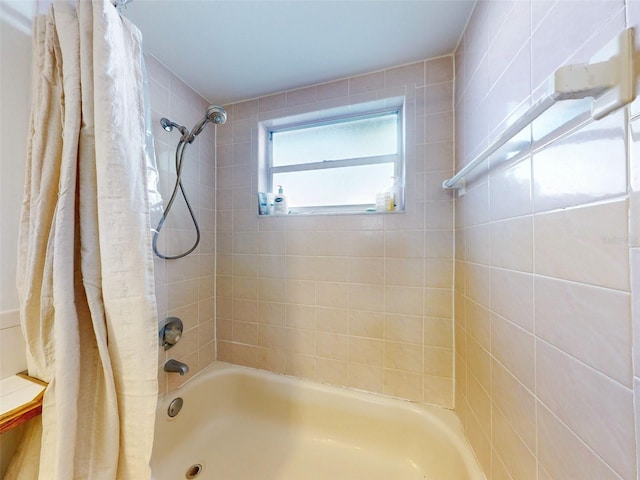 bathroom with shower / bath combo with shower curtain