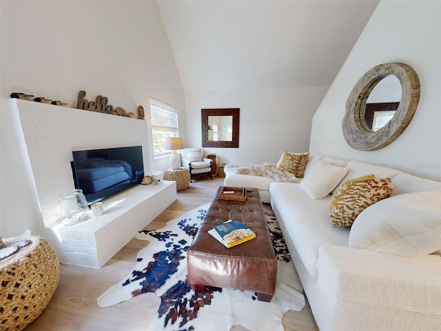 living room featuring light wood-type flooring and high vaulted ceiling