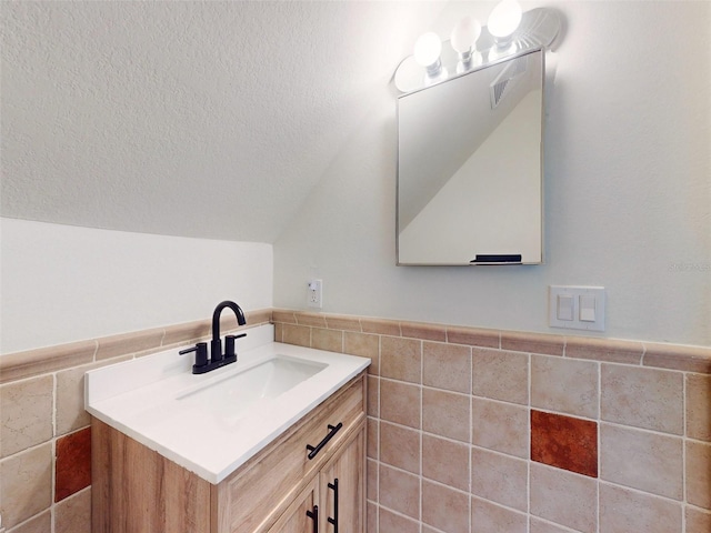 bathroom featuring vanity and tile walls