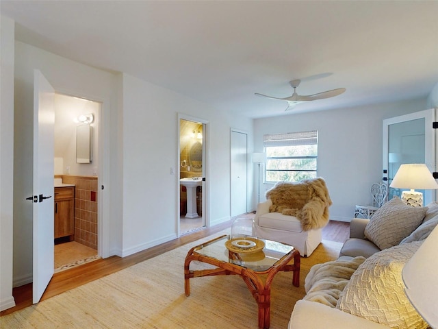 living room featuring light hardwood / wood-style floors, ceiling fan, and sink