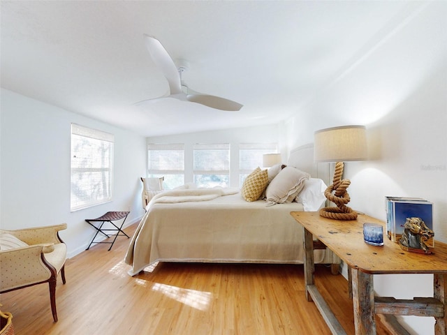 bedroom with ceiling fan, light hardwood / wood-style floors, and vaulted ceiling