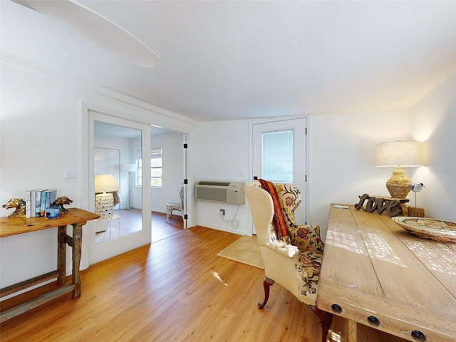 bedroom with an AC wall unit and light wood-type flooring