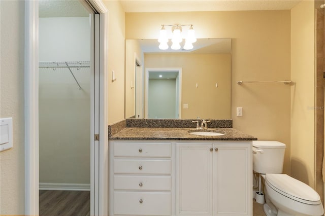 bathroom featuring vanity, toilet, wood-type flooring, and a textured ceiling