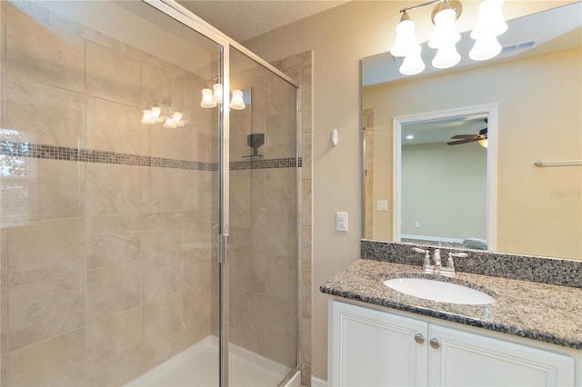 bathroom featuring an enclosed shower, vanity, and ceiling fan