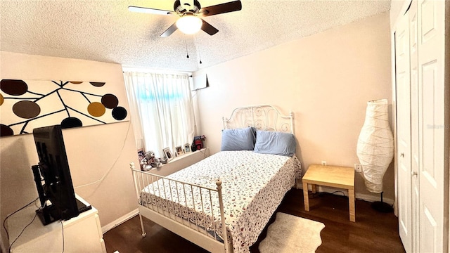 bedroom featuring a textured ceiling, ceiling fan, and dark wood-type flooring