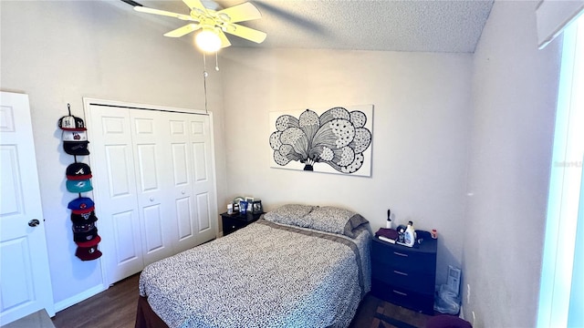 bedroom featuring dark hardwood / wood-style flooring, a textured ceiling, vaulted ceiling, ceiling fan, and a closet