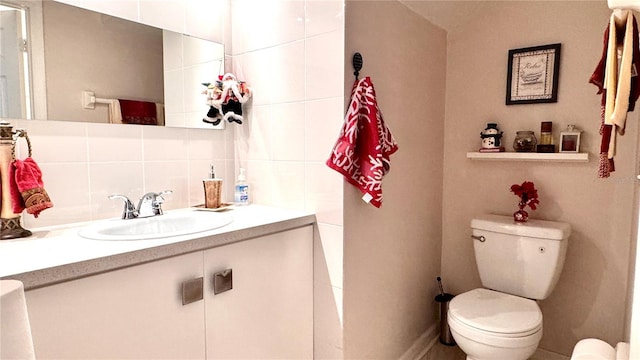 bathroom with vanity, tasteful backsplash, and toilet