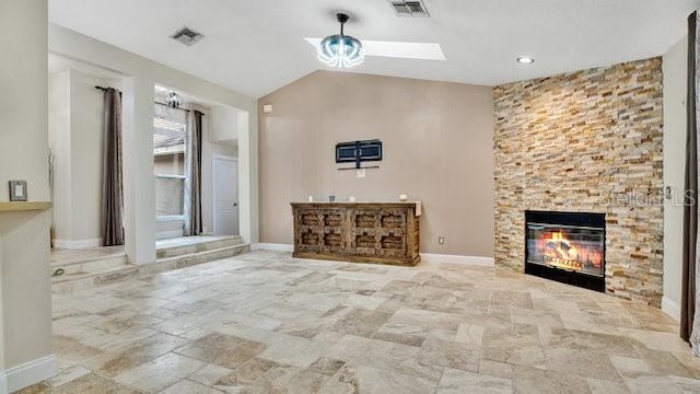 unfurnished living room featuring lofted ceiling with skylight and a fireplace