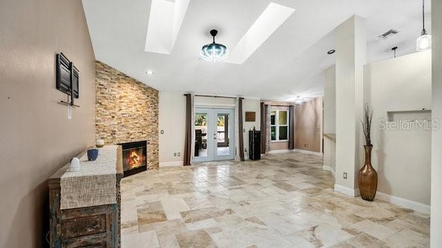 hall featuring a skylight, french doors, and high vaulted ceiling