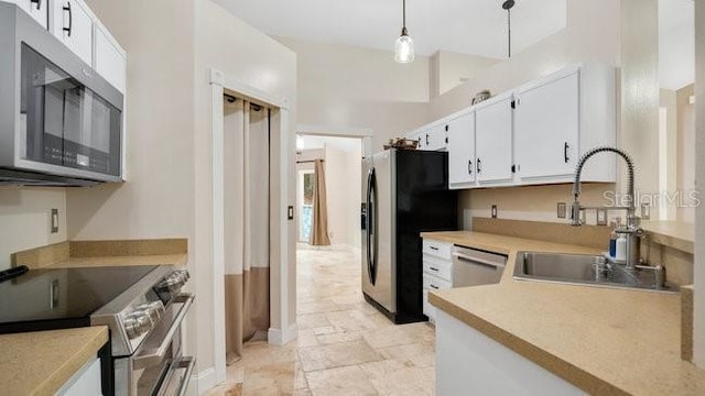 kitchen with white cabinets, decorative light fixtures, sink, and stainless steel appliances