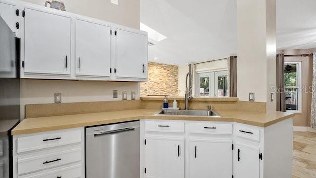 kitchen featuring dishwasher, white cabinetry, a healthy amount of sunlight, and sink