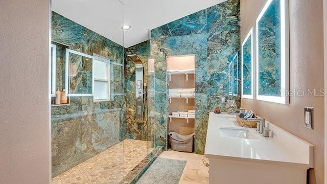 bathroom featuring tiled shower and vanity