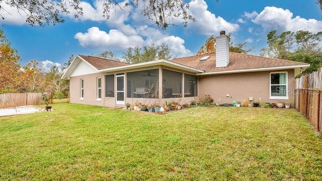 rear view of house with a lawn and a sunroom