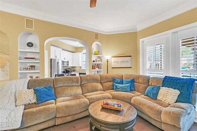 living room featuring built in shelves and ornamental molding