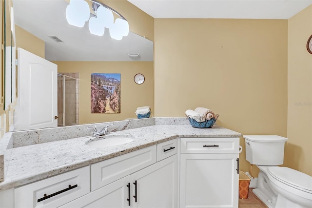 bathroom with tile patterned floors, vanity, toilet, and a shower with shower door