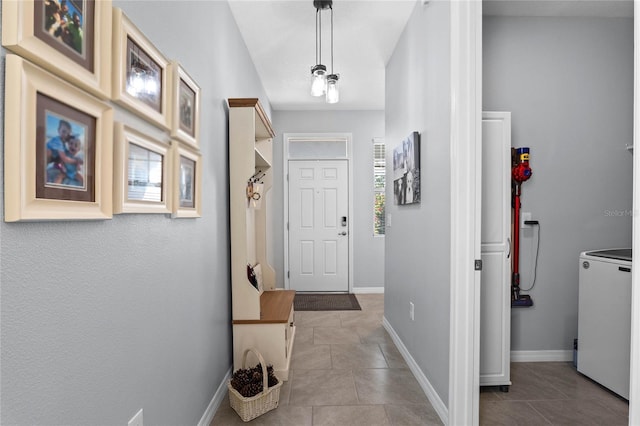 corridor with light tile patterned floors and washer / clothes dryer