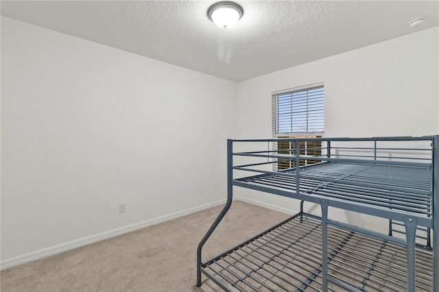 bedroom featuring carpet floors and a textured ceiling