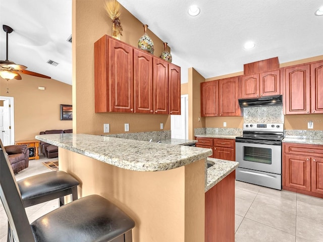 kitchen featuring kitchen peninsula, stainless steel electric range oven, a breakfast bar, and vaulted ceiling