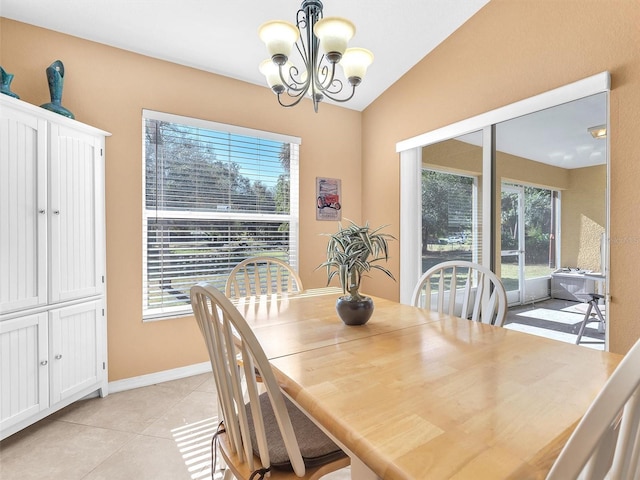 tiled dining space with a chandelier, plenty of natural light, and lofted ceiling