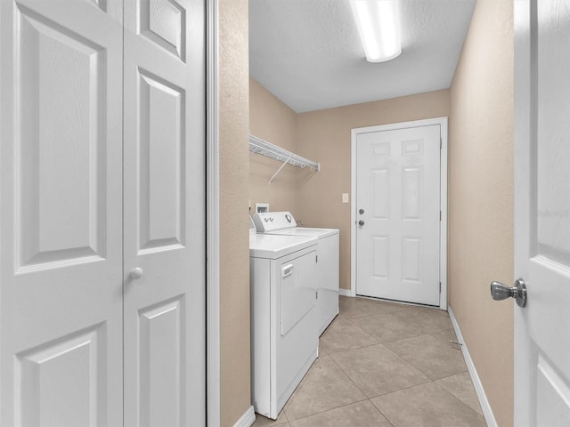 laundry area with light tile patterned flooring, independent washer and dryer, and a textured ceiling