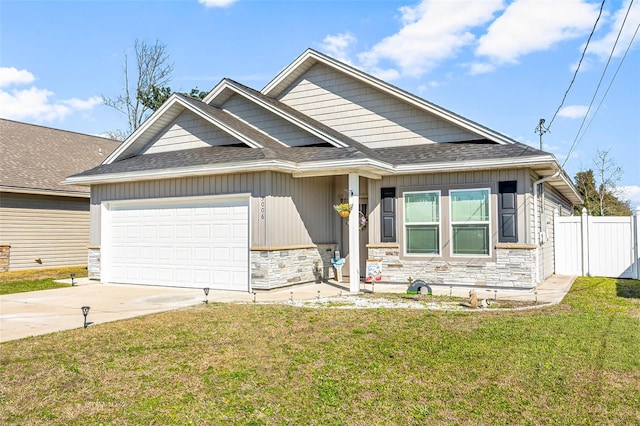 view of front of property with a garage, stone siding, driveway, and fence