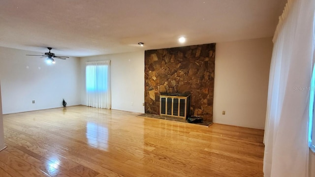 unfurnished living room featuring hardwood / wood-style floors, ceiling fan, and a fireplace