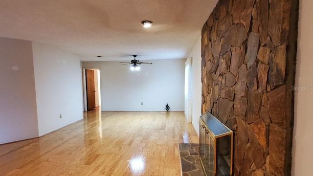 unfurnished living room featuring ceiling fan and light wood-type flooring