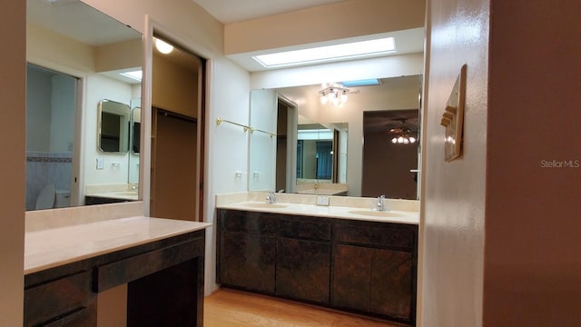 bathroom with ceiling fan, hardwood / wood-style floors, vanity, and toilet