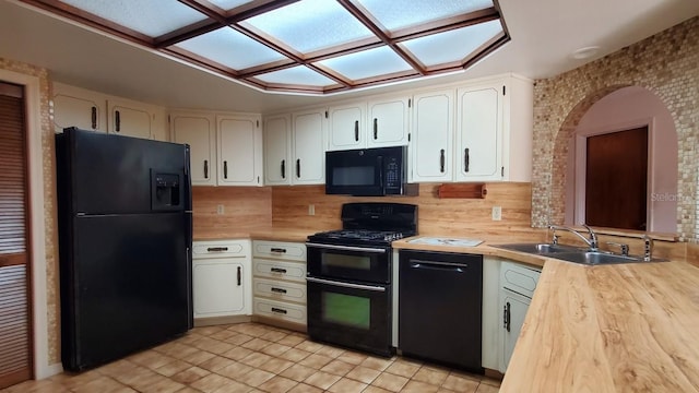 kitchen with white cabinets, light tile patterned floors, sink, and black appliances