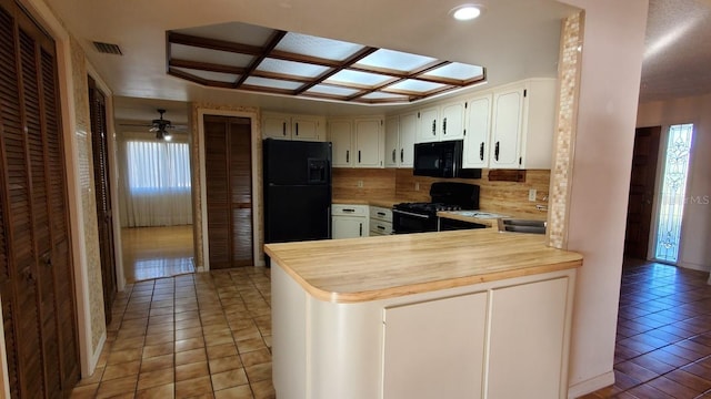 kitchen with kitchen peninsula, backsplash, ceiling fan, black appliances, and tile patterned flooring