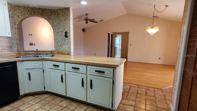 kitchen with ceiling fan with notable chandelier, sink, hanging light fixtures, vaulted ceiling, and black dishwasher