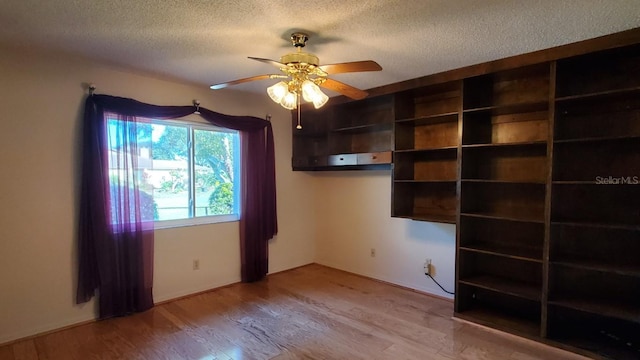 unfurnished room featuring hardwood / wood-style floors, ceiling fan, and a textured ceiling