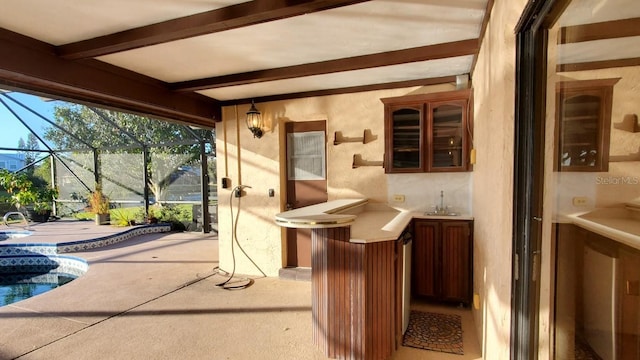 view of patio with glass enclosure and sink