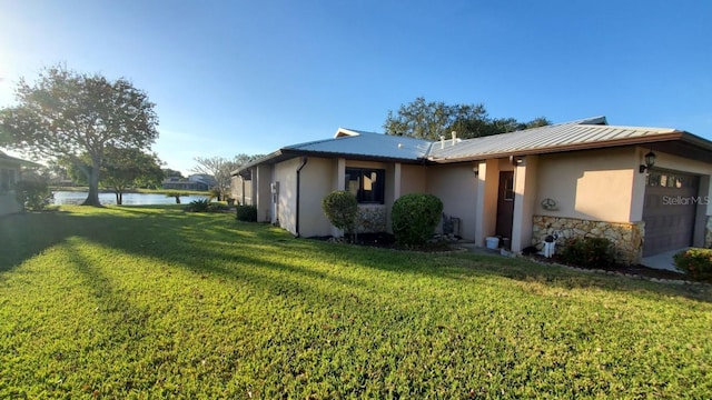 view of property exterior with a garage, a water view, and a yard