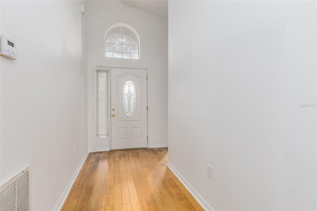 entrance foyer with light wood-type flooring and a high ceiling