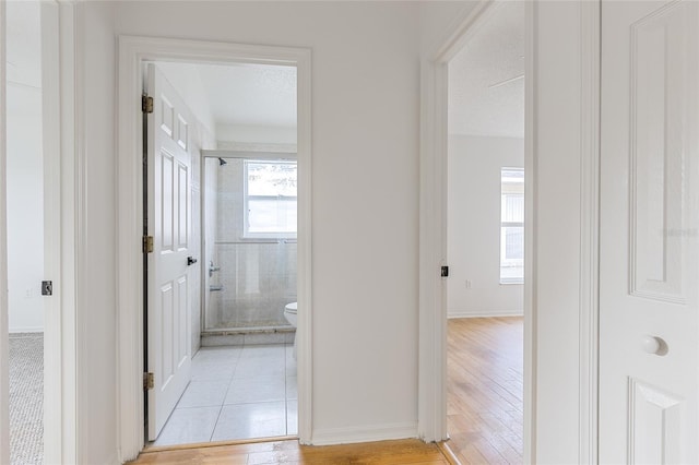 hall featuring a textured ceiling and light hardwood / wood-style floors